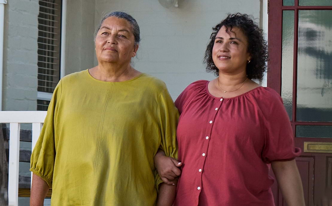 Actor portrayal of adult daughter walking outsite alongside her elderly mother with agitation that may happen with dementia due to Alzheimer's disease.