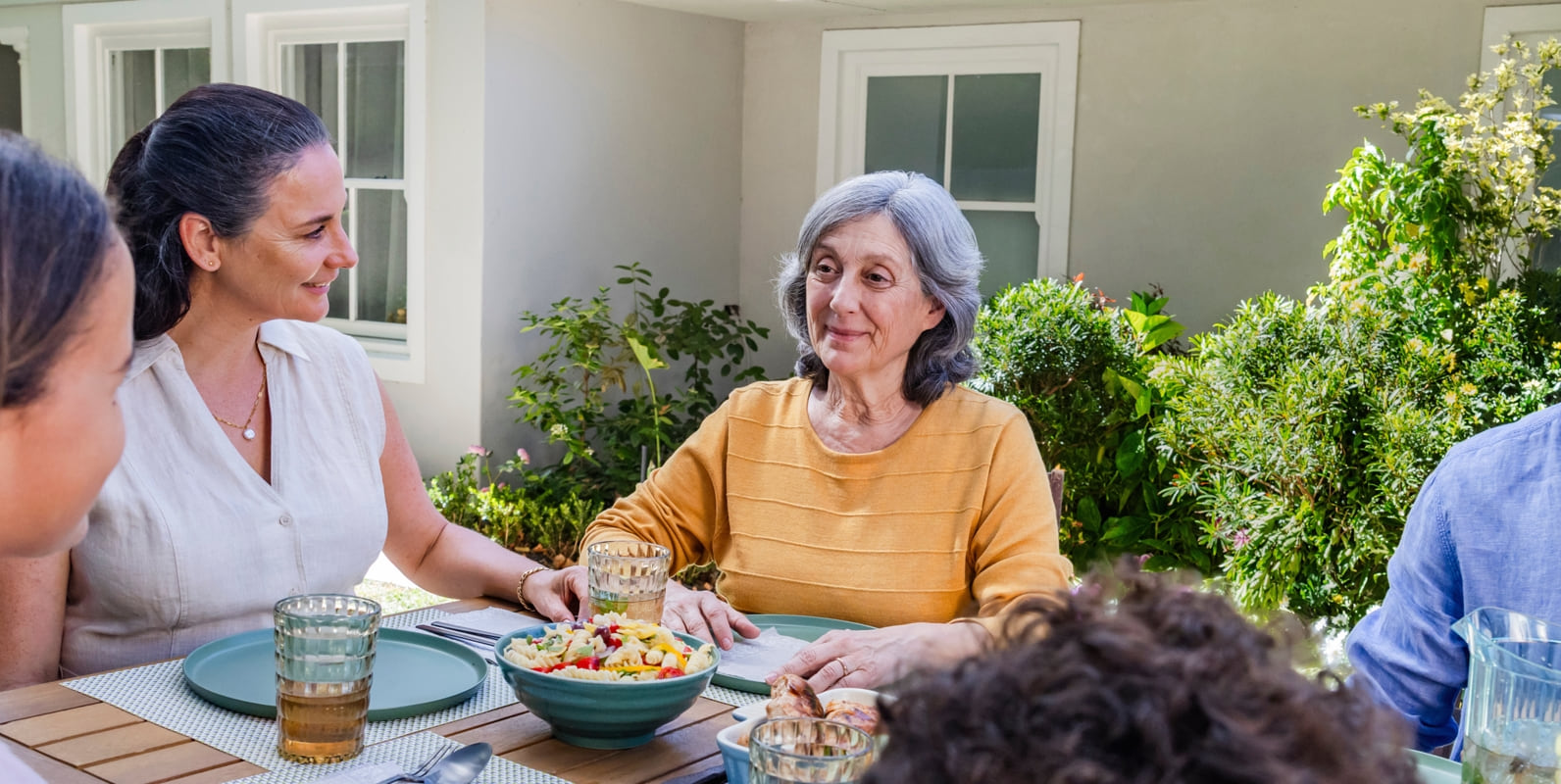 Representación actoral de una familia disfrutando de una cena al aire libre con su abuela quien vive con la agitación que puede ocurrir con la demencia debido a la enfermedad de Alzheimer.
