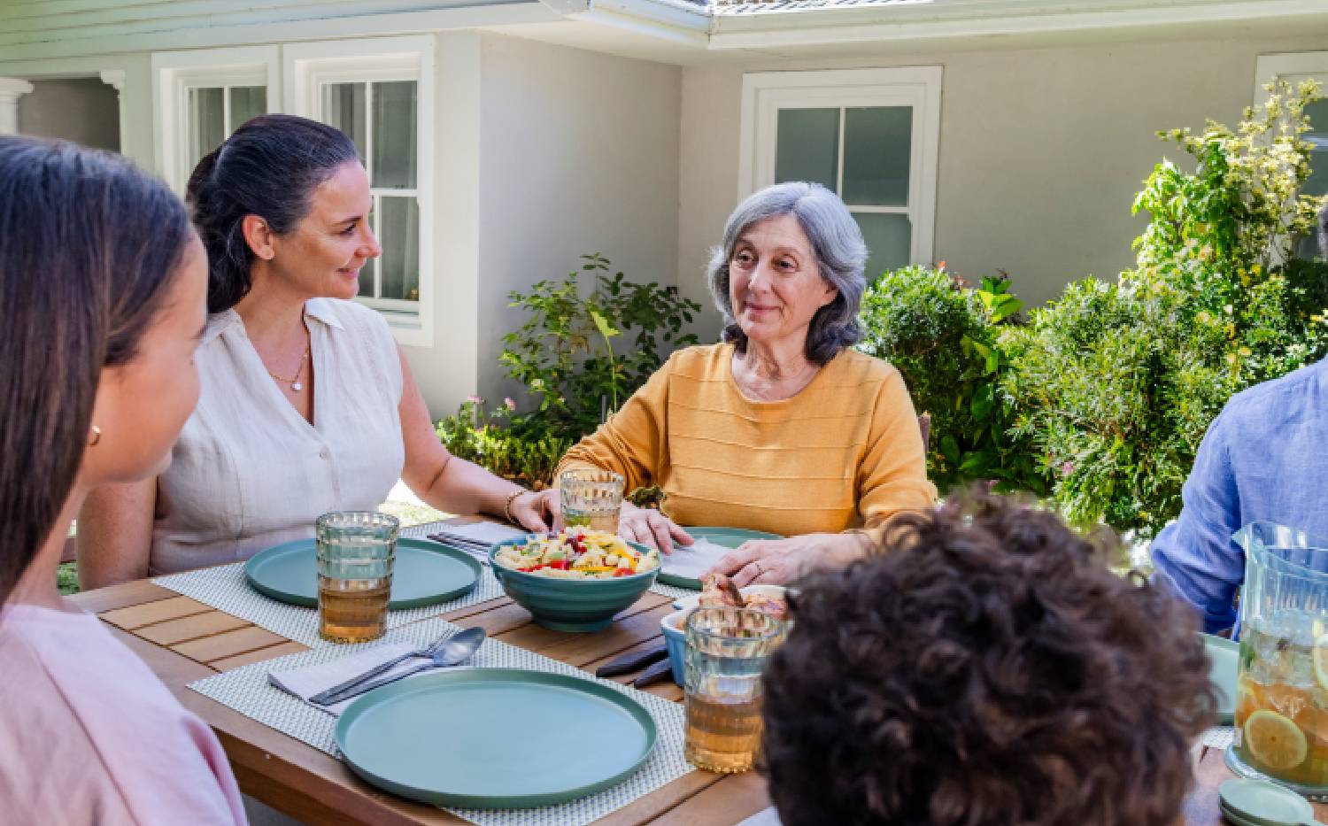Representación actoral de una familia disfrutando de una cena al aire libre con su abuela quien vive con la agitación que puede ocurrir con la demencia debido a la enfermedad de Alzheimer.