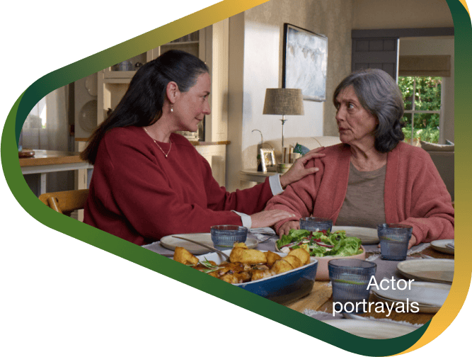 Actor portrayal of adult daughter comforting elderly mother over dinner who's living with agitation that may happen with dementia due to Alzheimer's disease.