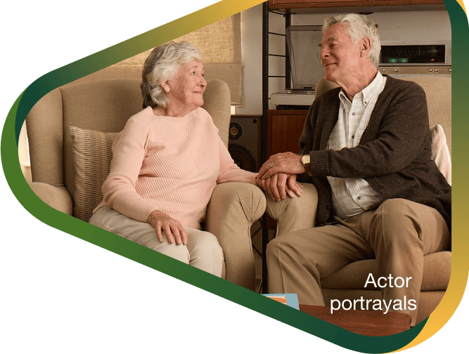 Actor portrayal of elderly man holding hands and smiling with his wife with agitation that may happen with dementia due to Alzheimer's disease.