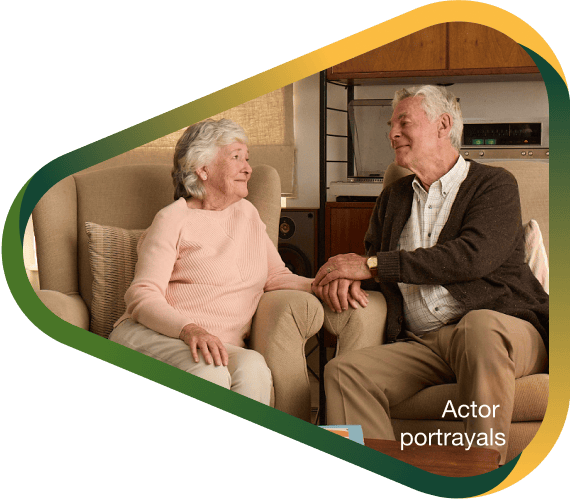 Actor portrayal of elderly man holding hands and smiling with his wife with agitation that may happen with dementia due to Alzheimer's disease.