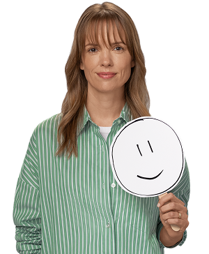 Female REXULTI user smiling while holding smiley face sign.