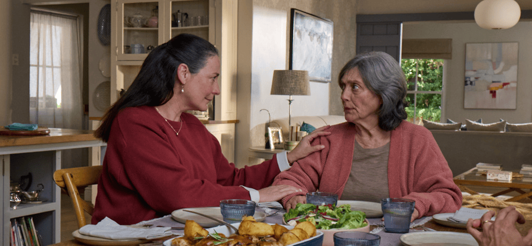 Actor portrayal of adult daughter comforting elderly mother over dinner who's living with agitation that may happen with dementia due to Alzheimer's disease.