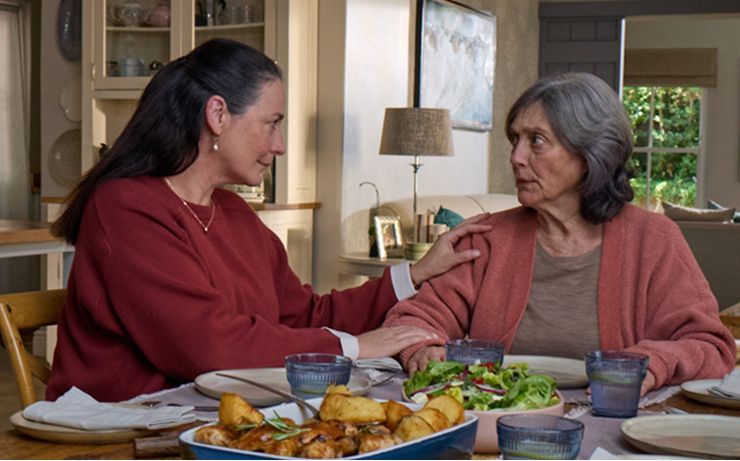 Actor portrayal of adult daughter comforting elderly mother over dinner who's living with agitation that may happen with dementia due to Alzheimer's disease.