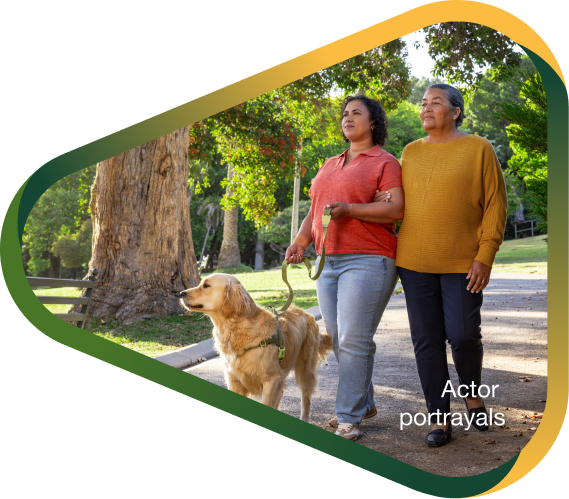 Actor portrayal of adult daughter walking dog in sunny park with elderly mother, who has agitation that may happen with dementia due to Alzheimer's disease.