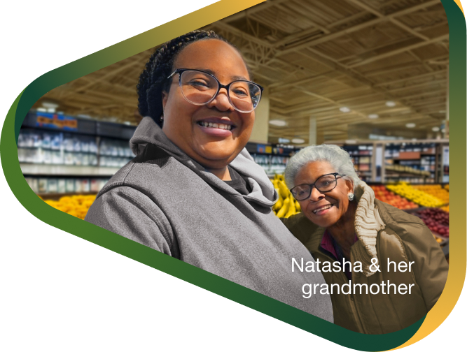 Caregiver Natasha and her grandmother with agitation that may happen with dementia due to Alzheimer's disease hugging and smiling in supermarket aisle.