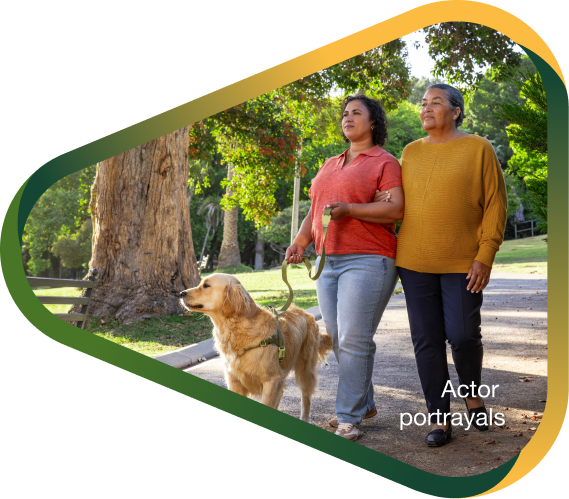 Actor portrayal of adult daughter walking dog in sunny park with elderly mother, who has agitation that may happen with dementia due to Alzheimer's disease.