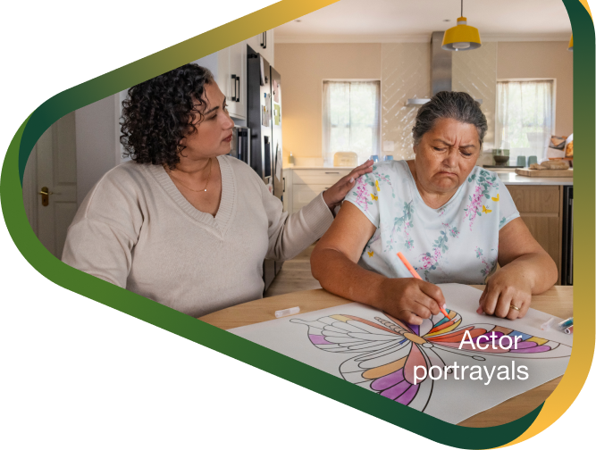 Actor portrayal of adult daughter comforting elderly mother coloring an image of a butterlfy who's living with agitation that may happen with dementia due to Alzheimer's disease.