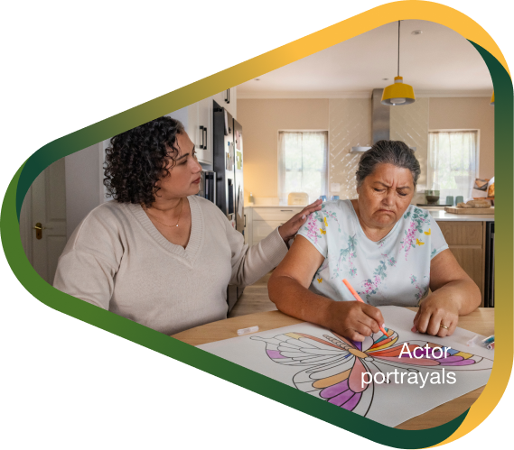 Actor portrayal of adult daughter comforting elderly mother coloring an image of a butterlfy who's living with agitation that may happen with dementia due to Alzheimer's disease.