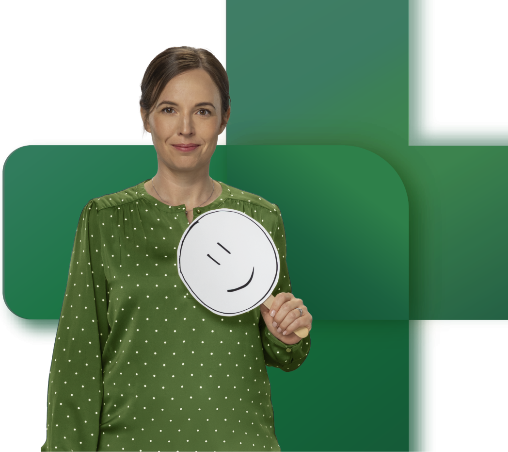 REXULTI for depression user smiling while holding smiley face sign.