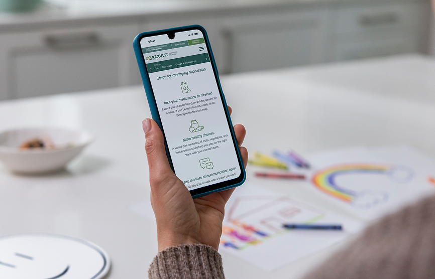 REXULTI for depression user holding phone with REXULTI Tools and Resources page onscreen